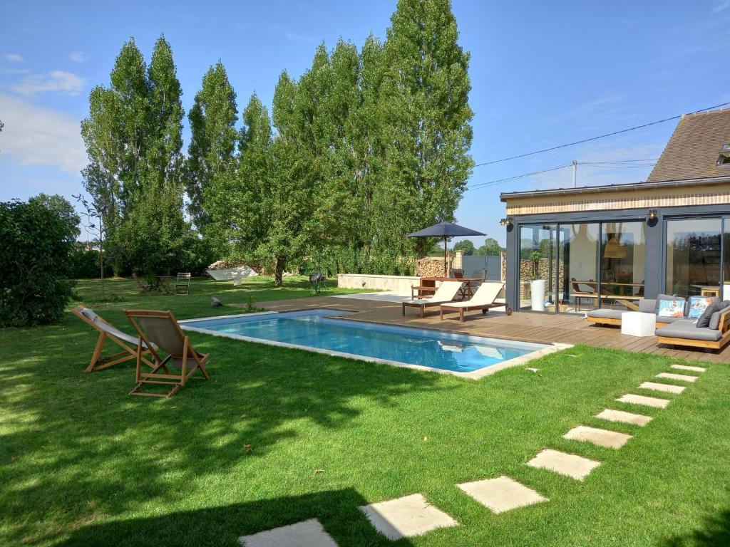 a yard with a swimming pool and a house at CountrySide Heaven in Neuilly-sur-Eure