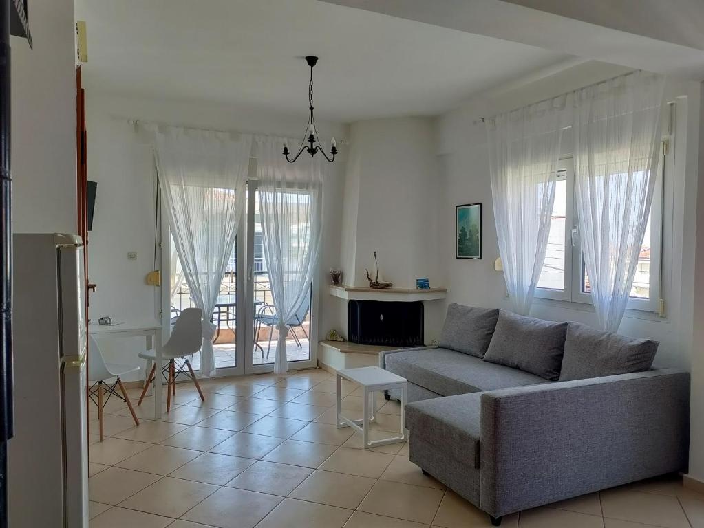 a living room with a couch and a fireplace at O&A Kallithea in Kallithea Halkidikis