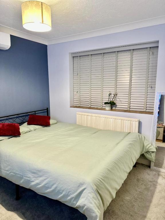 a bedroom with a large white bed with red pillows at 40 Kennett gardens in Gloucester