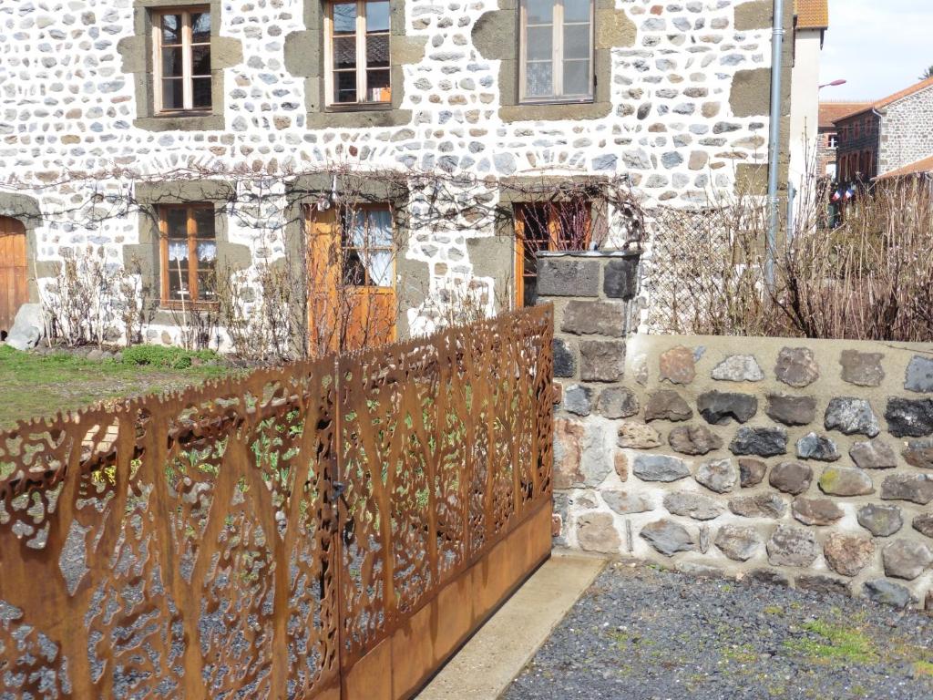 an old stone house with a wooden fence at la Loge à SANSSAC in Sanssac-lʼÉglise