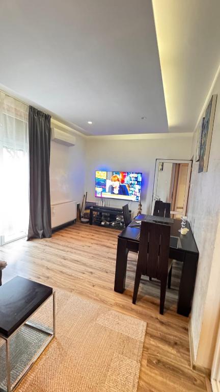 a living room with a table and a television at Apartamento Elit in Dimitrovgrad