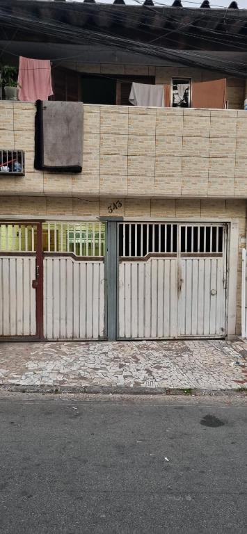 a wooden building with a gate and a building at Meu Aconchego in Embu