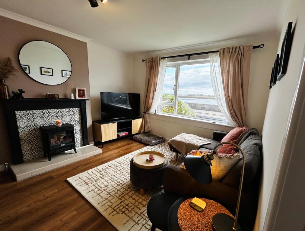 a living room with a couch and a fireplace at Newton Marina View in Stornoway