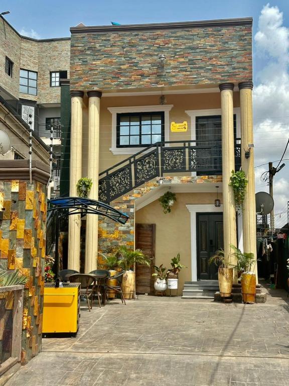 a house with a balcony and a table in front of it at Afia Cottage Inn in Ayaso