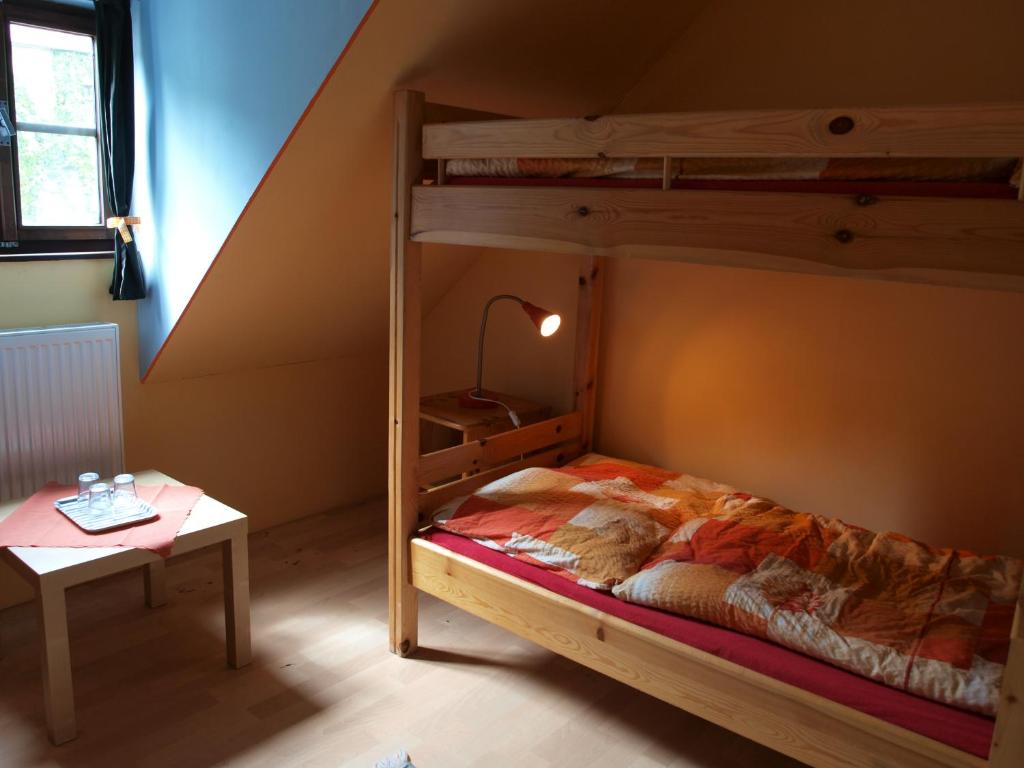 a bedroom with a bunk bed and a table at Hostel Skautský dom in Banská Štiavnica
