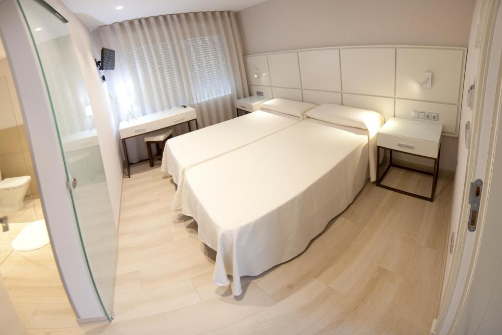 Postel nebo postele na pokoji v ubytování Hostal Loimar