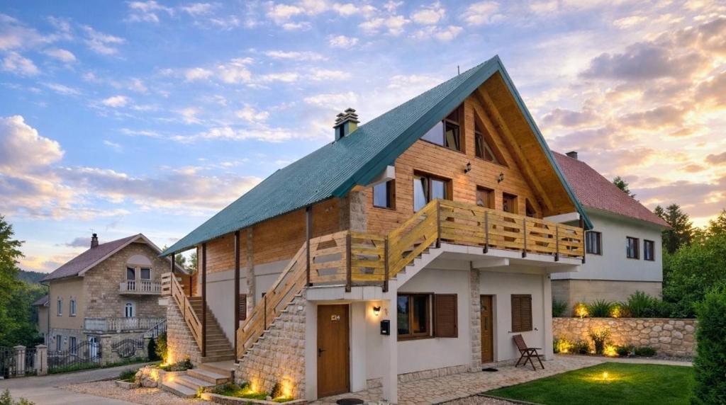 a house with a gambrel roof with a garage at Monte Pino Lux Apartments in Žabljak