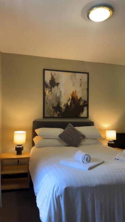 a bedroom with a large white bed with two lamps at The Turf Hotel in Richmond