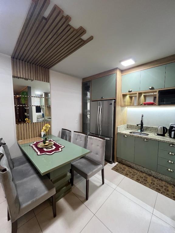 a kitchen with a table and chairs and a refrigerator at Lindo apartamento todo equipado in Criciúma