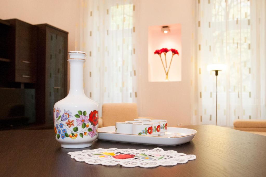 una mesa con un jarrón y un plato sobre una mesa en Charlotte Apartment Close to Opera, en Budapest