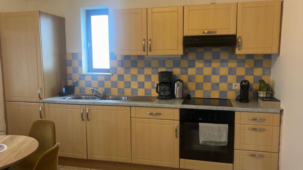 a kitchen with wooden cabinets and a sink and a window at Appartement chic bien situé in Mons