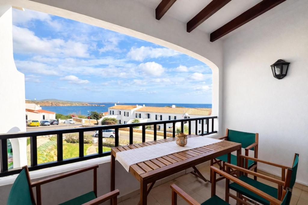a table and chairs on a balcony with a view of the ocean at Apartamento Natalia in Menorca