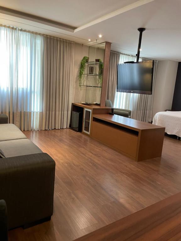 a hotel room with a bed and a desk at Sequoia - Alphaville in Barueri
