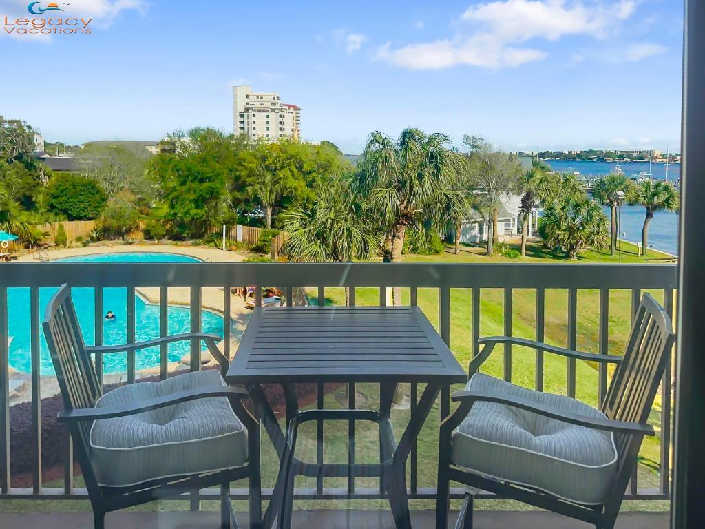 a table and chairs on a balcony with a view of a pool at Pirates Bay B303 in Fort Walton Beach