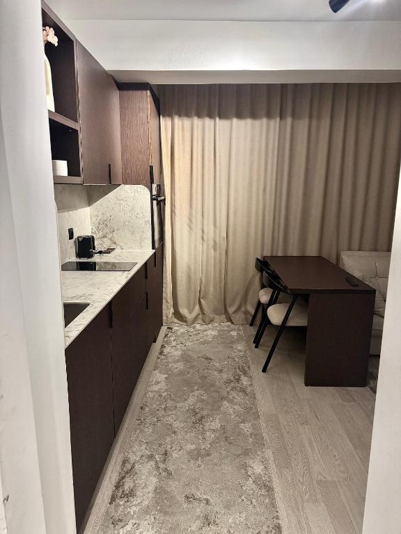 a small kitchen with a desk and a table at Deluxe Apartment 1 in Gnjilane