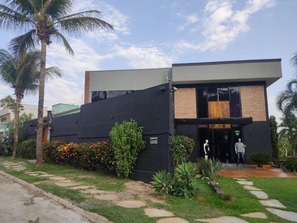 a black house with a palm tree in front of it at jaó, mazzahome in Goiânia