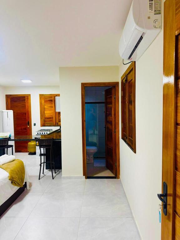 a bedroom with a door leading to a kitchen with a kitchen at Bigorú Flats in Itacaré