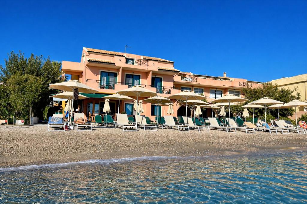 a hotel with chairs and umbrellas on a beach at MarieChristine Suites in Mesongi