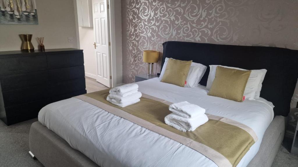 a bedroom with a bed with towels on it at Greatmindz abode in Kingshurst