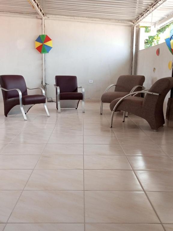 a waiting room with chairs and an umbrella on the wall at Próximo do carnaval em Olinda in Olinda