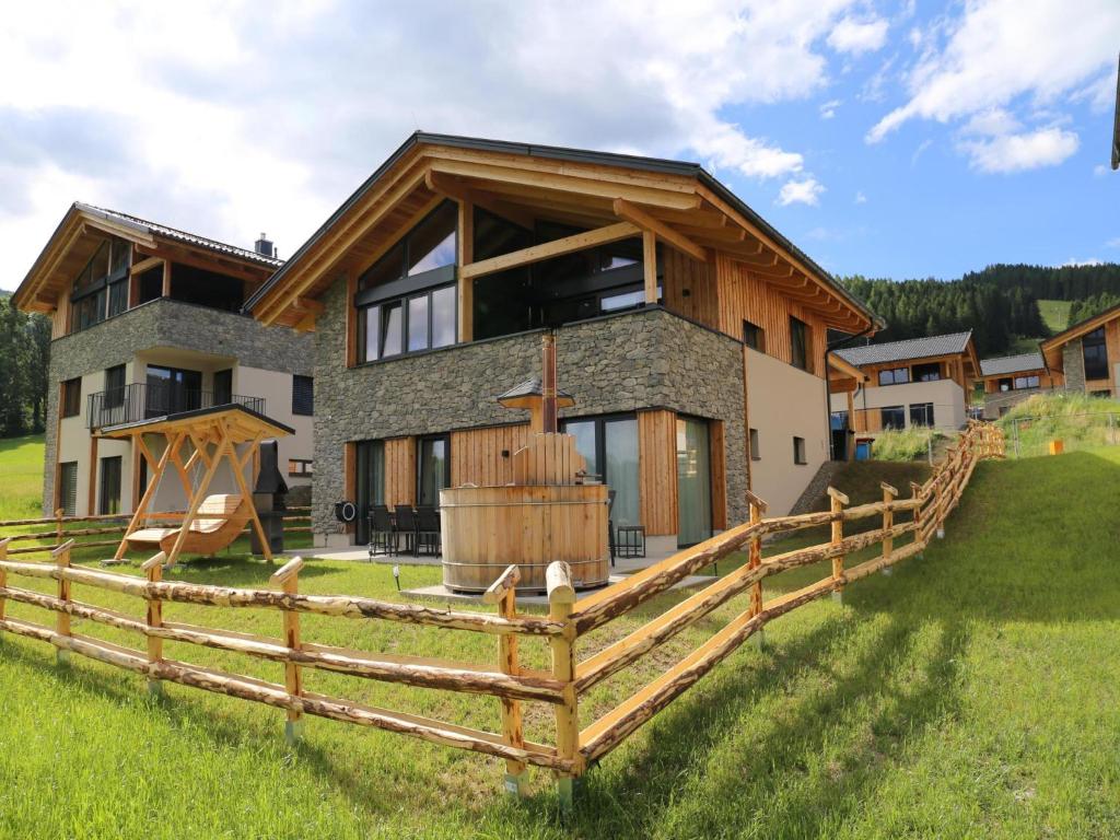 a house with a wooden fence in front of it at Grebenzen Lodge 44 in Sankt Lambrecht