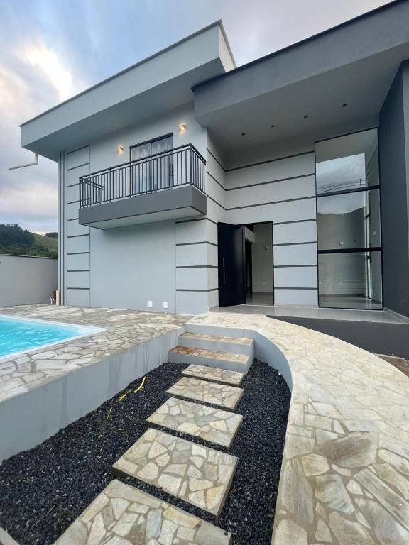 a house with a swimming pool and a balcony at Pousada Vila Palmital in Paraty