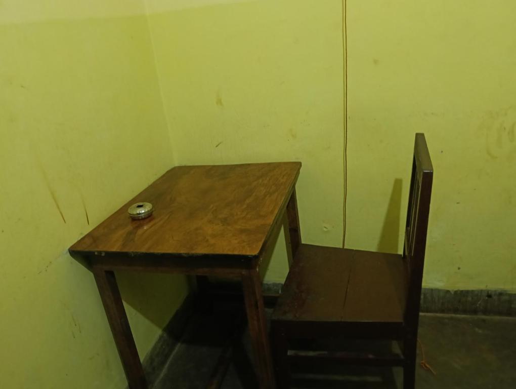 a wooden table and a chair in a room at Hotel Swapnapuri in Bhubaneshwar