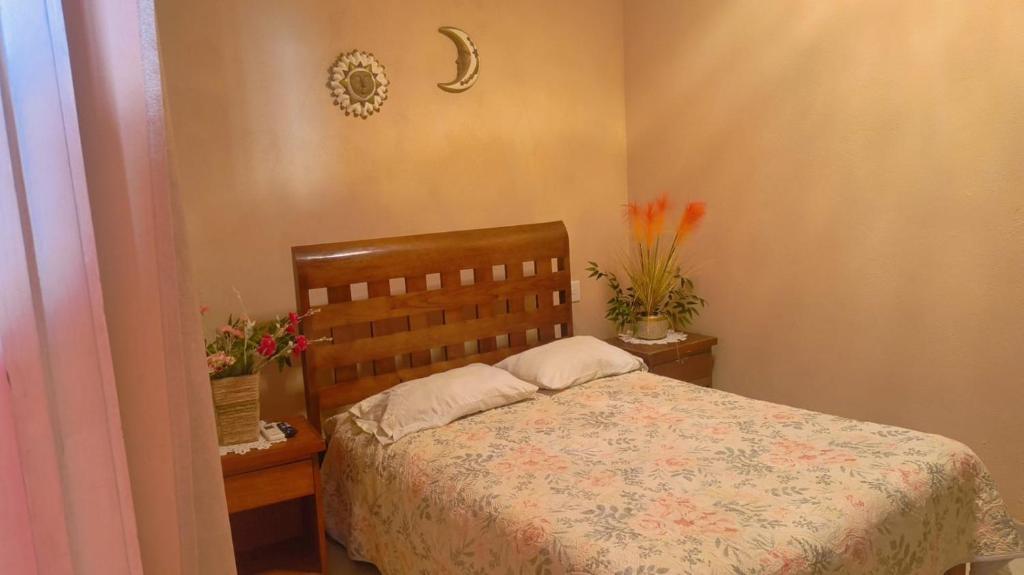 a bedroom with a bed with flowers on it at Hotel Ricarda Yopes Acapulco in Acapulco