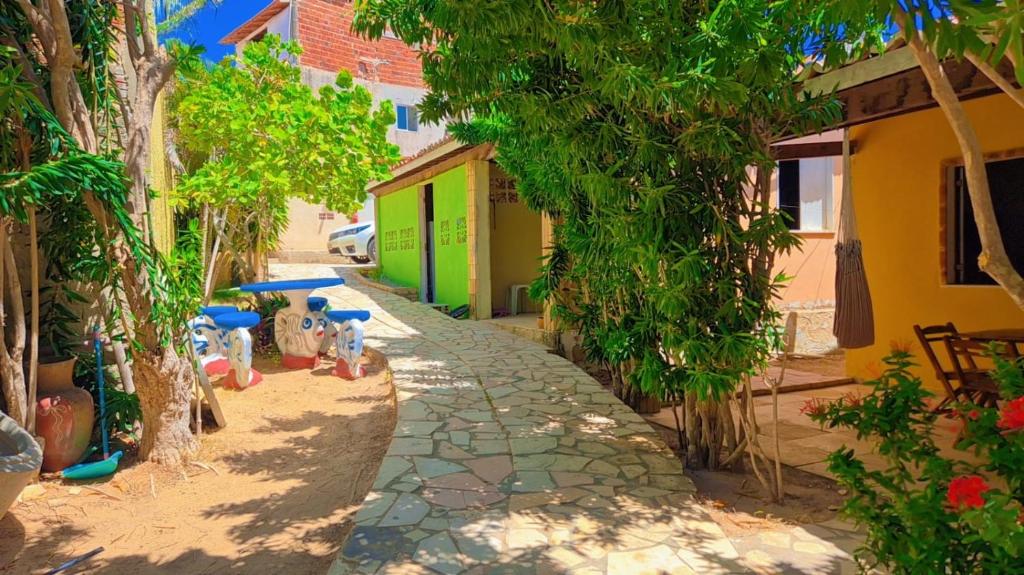 a cobblestone alley with trees and a building at Condomínio em Canoa Quebrada in Aracati