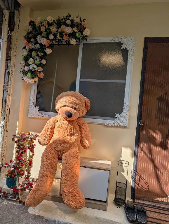a large teddy bear sitting on the side of a building at Travel Light in Tainan