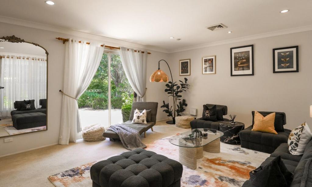a living room filled with furniture and a large window at Linden Getaway Bowral in Bowral