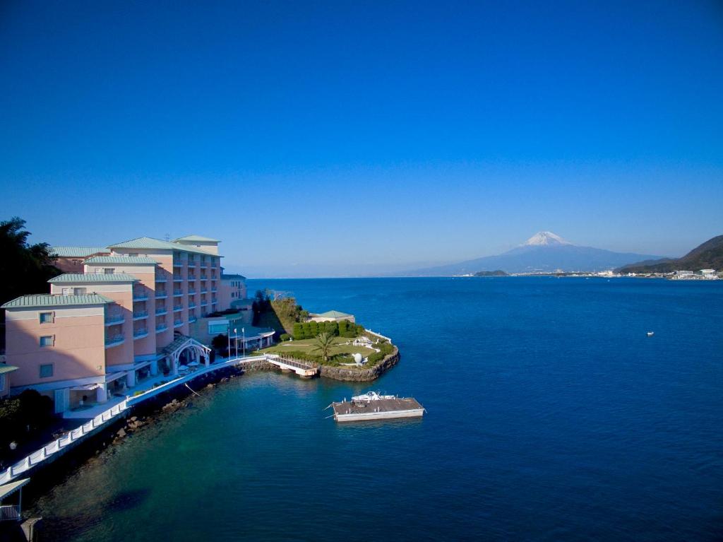 ein großes Gebäude mit einem Boot im Wasser in der Unterkunft Awashima Hotel in Numazu