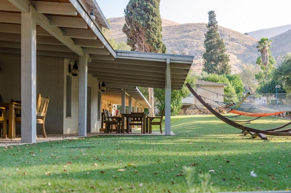a porch with a hammock and a table and chairs at Bait Alfa Kibbutz Country Lodging in Bet Alfa