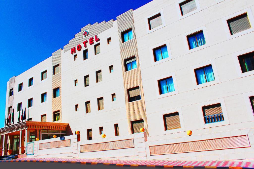 a large white building with a red hotel at Rest Hills Hotel in Amman