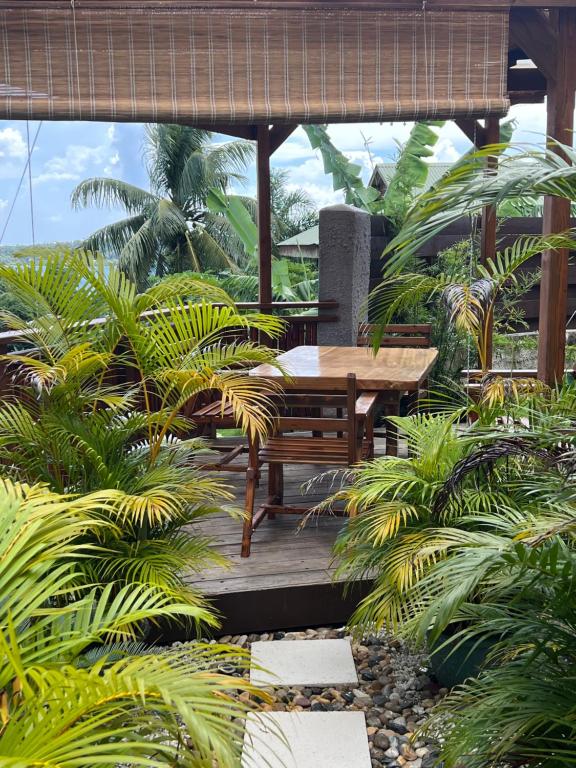 a wooden deck with a table and some plants at Manuia House in Bora Bora
