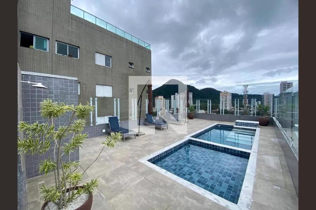 a swimming pool on the roof of a building at Lindo Apê Canto do Forte com lazer completo in Praia Grande