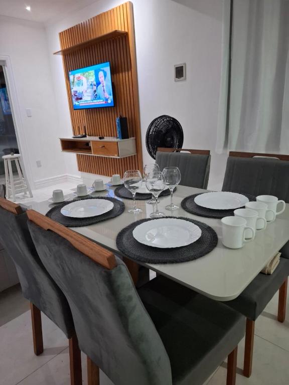 a dining room table with glasses and plates on it at Recanto do Sol em Marica in Maricá