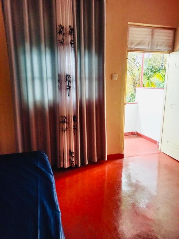 a living room with a door and a room with a hard wood floor at Lagoon Stay in Moraketiara