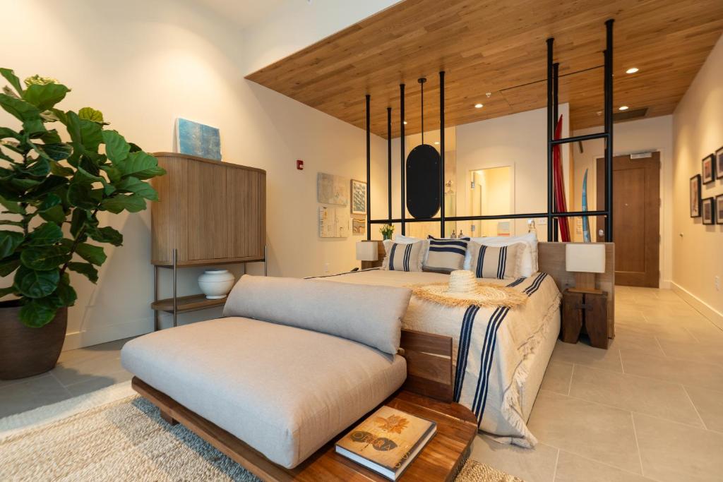 ein großes Schlafzimmer mit einem Bett und einem Stuhl in der Unterkunft The Sitio in Virginia Beach