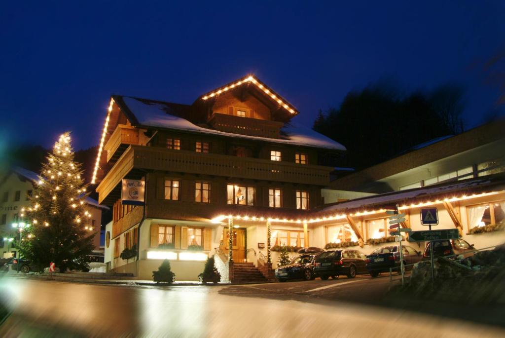 a building with a christmas tree in front of it at Sporthotel Sonne in Schruns