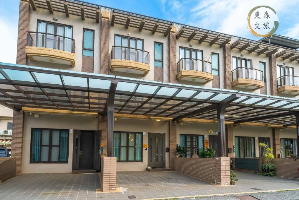 a building with awnings and balconies on it at 水母漂民宿-免費停車-寵物友善-無門禁24小時進出-東森文旅-包棟優惠中 in Toucheng