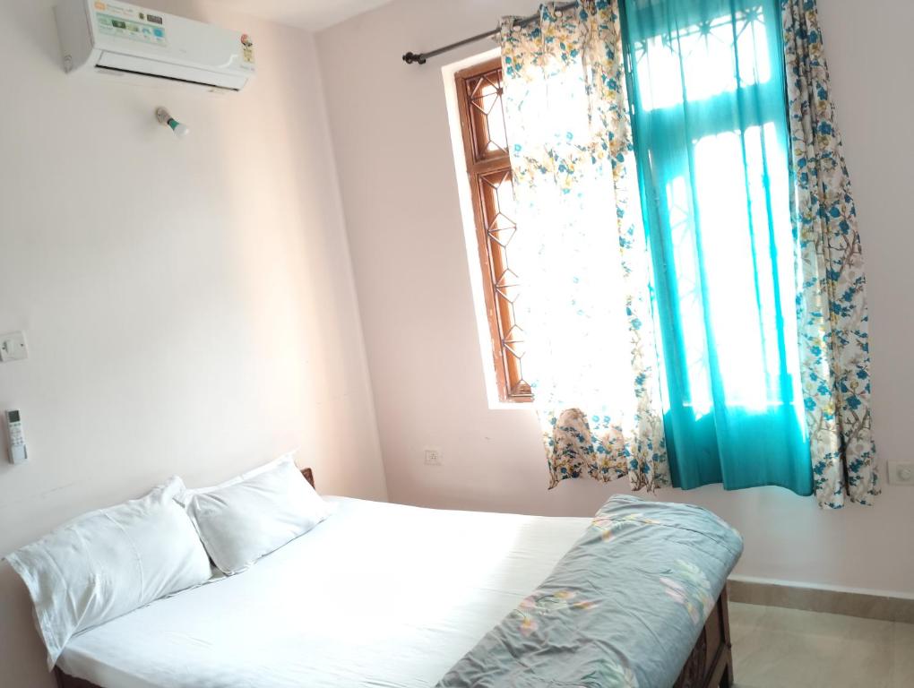 a small bedroom with a bed and a window at Rich nest apartments colva in Colva