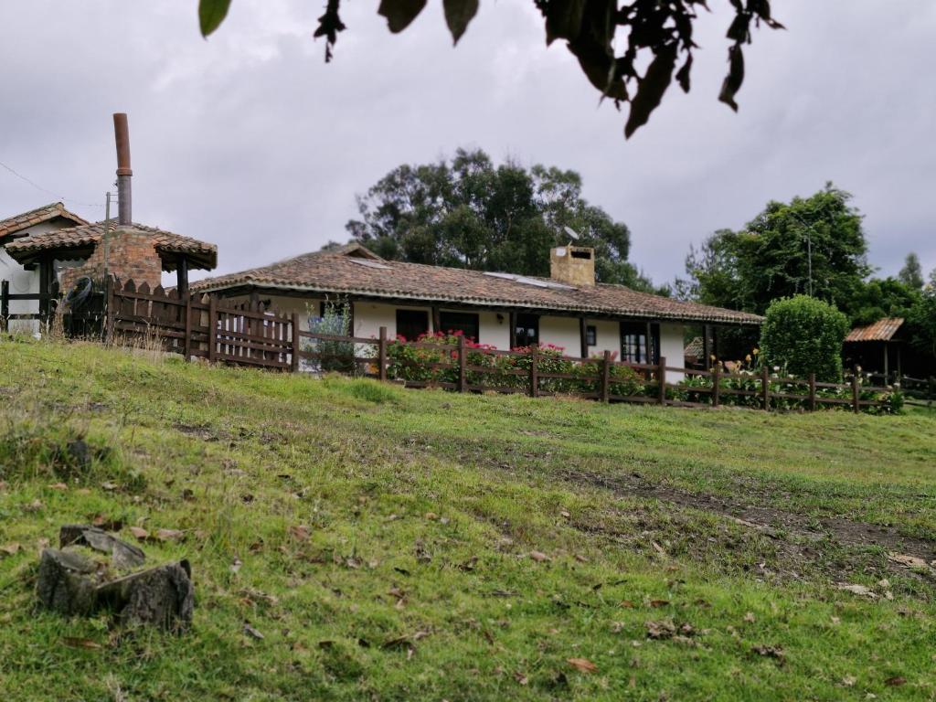 a house on a hill with a grassy field at Finca San Pablo in Subachoque
