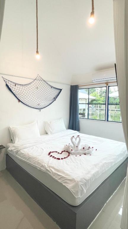 a bedroom with a bed with a hammock above it at มาทาเลรีสอร์ท in Ang Thong