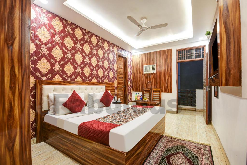 a bedroom with a large bed with red pillows at Hotel Fabulous - Delhi International Airport in New Delhi