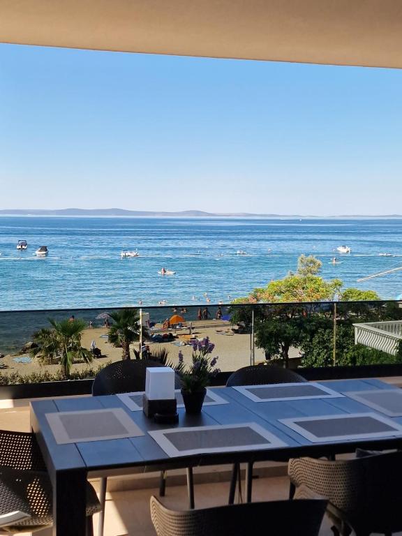 a table on a balcony with a view of the beach at Dinary Apartman in Vir