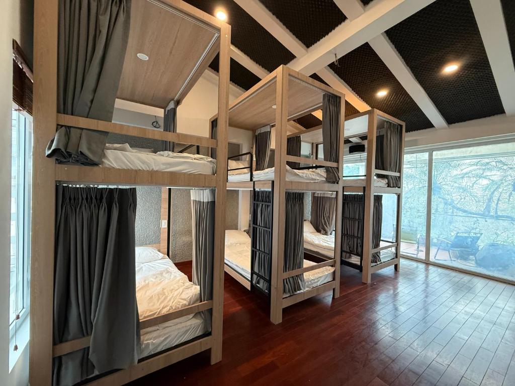 a room with three bunk beds in a room at Spuds&Bunks Hostel in Hanoi