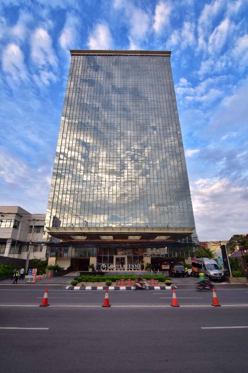 a large building with orange cones in a parking lot at Louis Kienne Hotel Pandanaran in Semarang