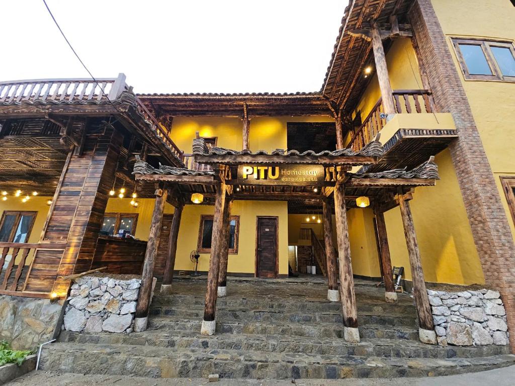 a building with stairs leading up to the entrance at PiTu Homestay in Dồng Văn