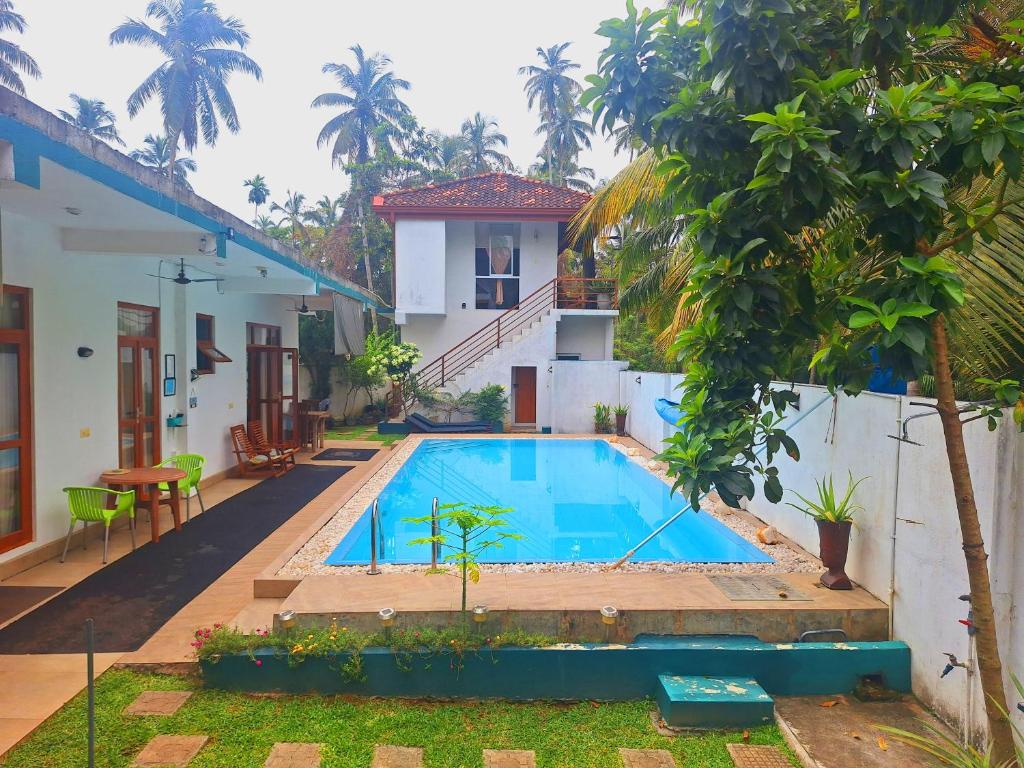 a swimming pool in the backyard of a house at Coconut Villa in Bentota